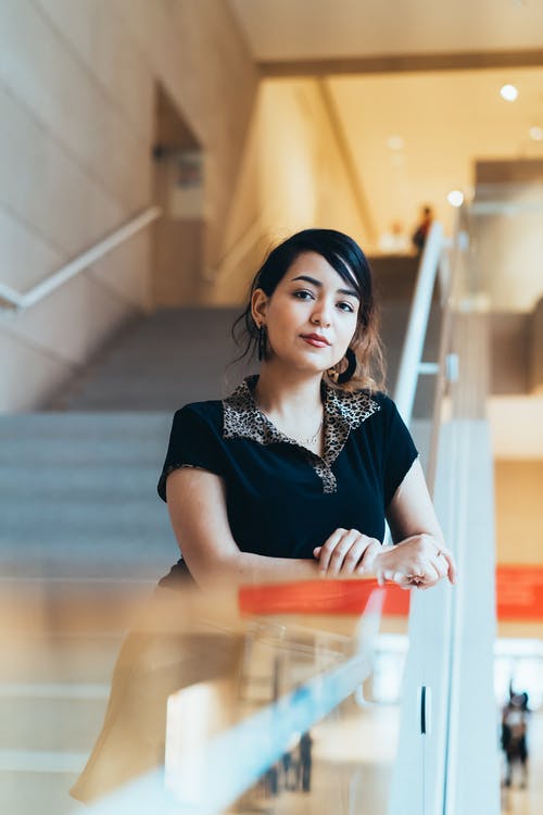 女人聚焦在楼梯栏杆上的焦点摄影 · 免费素材图片