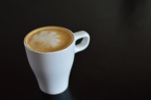 黑色表面上的白色陶瓷咖啡杯 · 免费素材图片