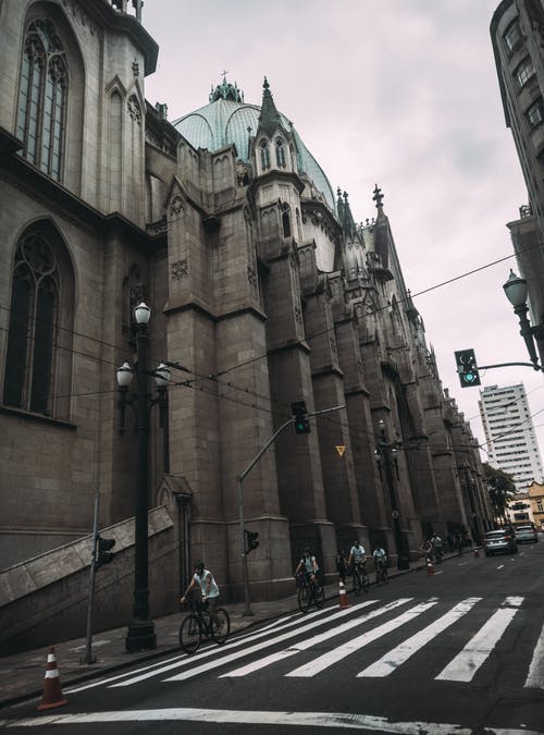 建筑物附近的人骑自行车 · 免费素材图片