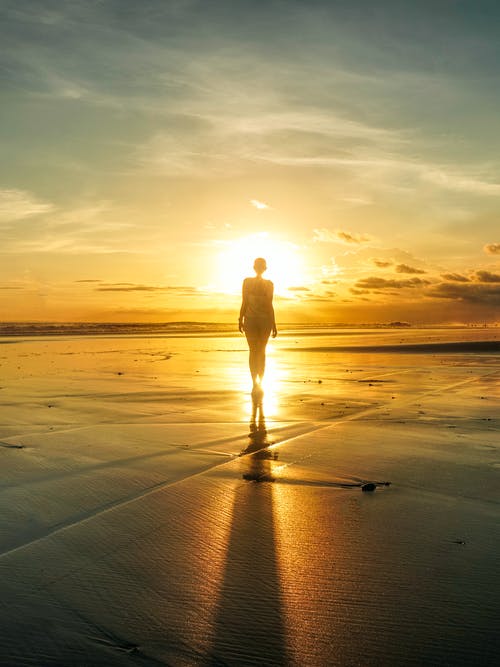 女人站在海边的剪影 · 免费素材图片
