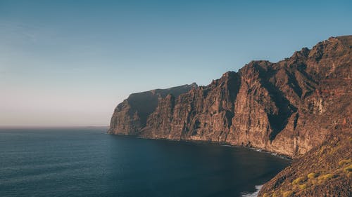 平静水域旁边的落基山 · 免费素材图片