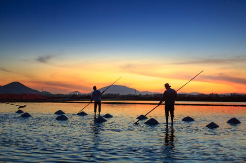 两名男子在水面上钓鱼的剪影 · 免费素材图片