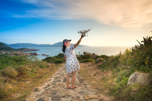 一个拿着无人机的女人的照片 · 免费素材图片