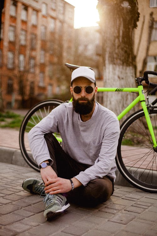 坐在自行车旁边的人的照片 · 免费素材图片