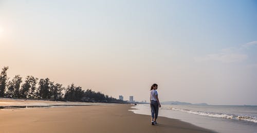 在水体附近的岸上行走的女人 · 免费素材图片