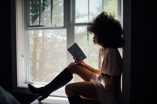 女人坐在窗口看书 · 免费素材图片