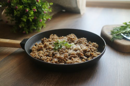 煮熟的食物，在木质表面上的煎锅上 · 免费素材图片