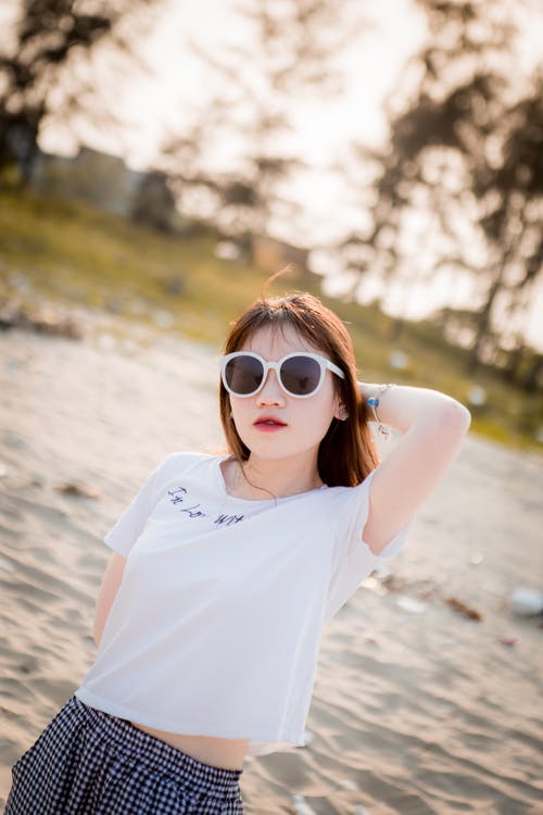 太阳镜和白色t恤摆姿势的女人照片 · 免费素材图片