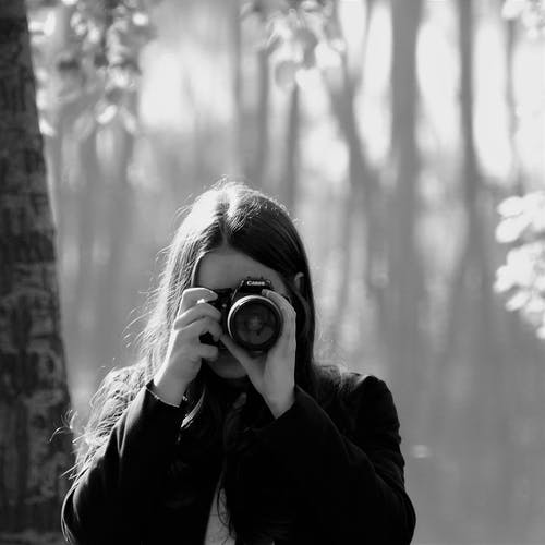 女人拿着照相机的灰度摄影 · 免费素材图片