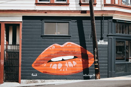黑色和橙色的嘴唇涂在建筑物的墙壁 · 免费素材图片