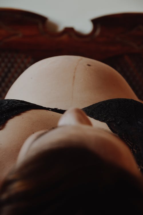 躺在她的背上的黑色胸罩的孕妇 · 免费素材图片