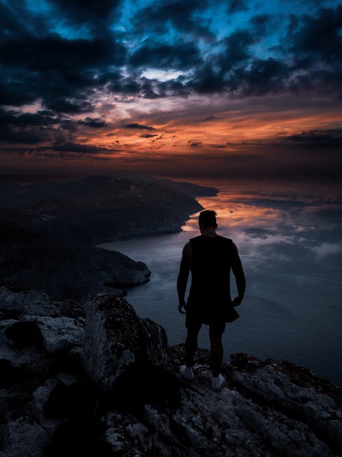 男子站在悬崖上的照片 · 免费素材图片