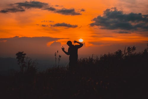 男子站在草地上的轮廓 · 免费素材图片