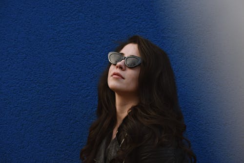 蓝墙构成的黑色太阳镜的女人的照片 · 免费素材图片