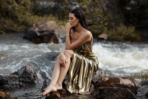 女人坐在河边的金丝管礼服 · 免费素材图片