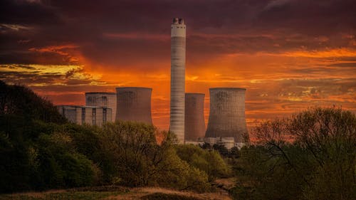 日落时橙色的天空下的白色核电站筒仓 · 免费素材图片