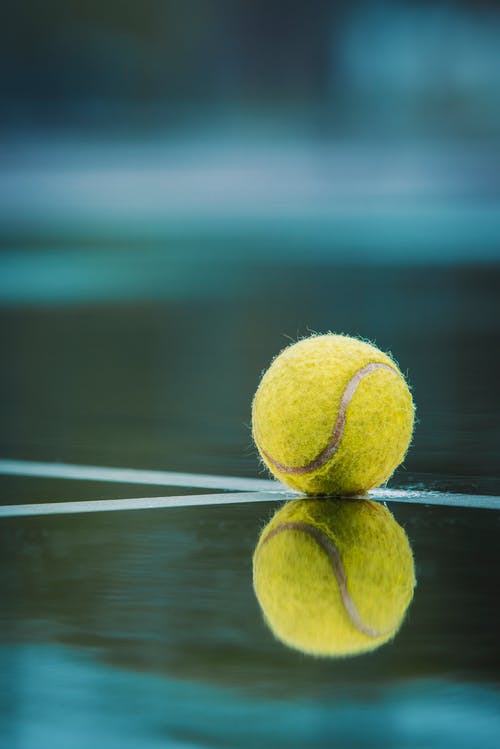 网球在地板上的选择性聚焦摄影 · 免费素材图片