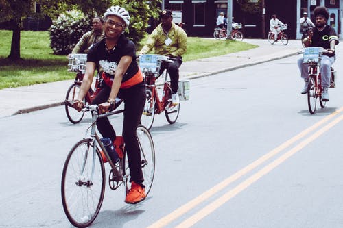 微笑的女士骑着自行车 · 免费素材图片