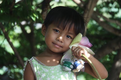 女孩抱着钥匙扣和一朵花 · 免费素材图片