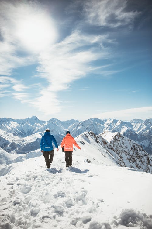 在积雪覆盖的山上行走的人 · 免费素材图片