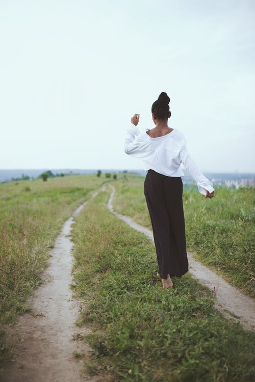 在草地上行走的女人的照片 · 免费素材图片