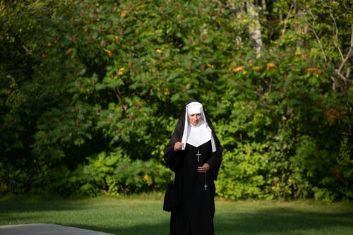走在树旁的修女 · 免费素材图片