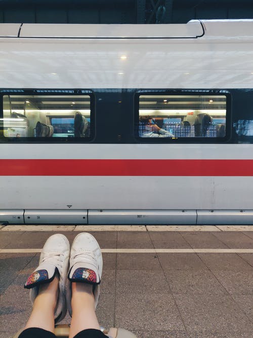 坐在火车附近的地板上的人的照片 · 免费素材图片