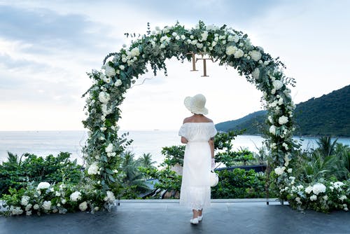 花乔木附近穿白色连衣裙的女人的照片 · 免费素材图片