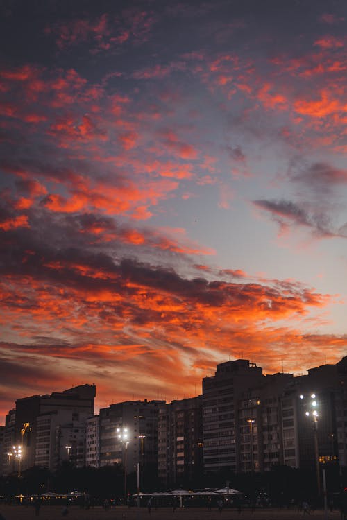日落时城市上空的橙色云 · 免费素材图片