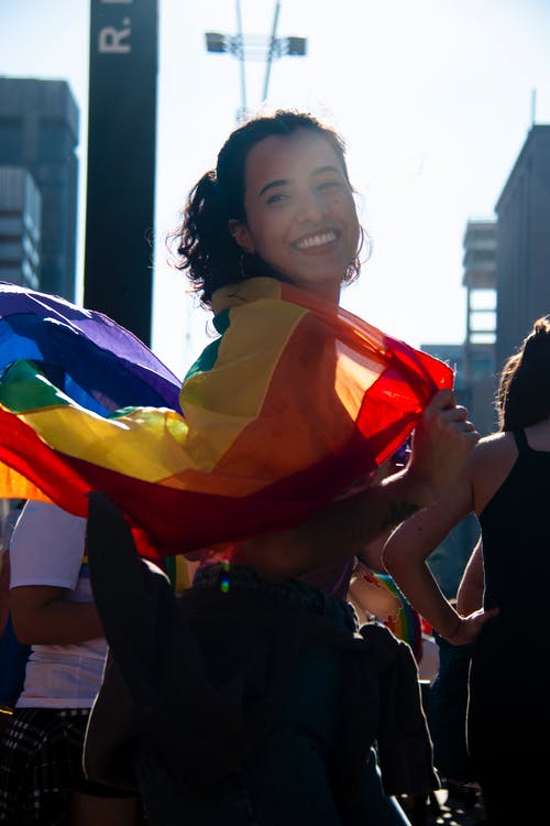 女人抱着彩虹旗 · 免费素材图片