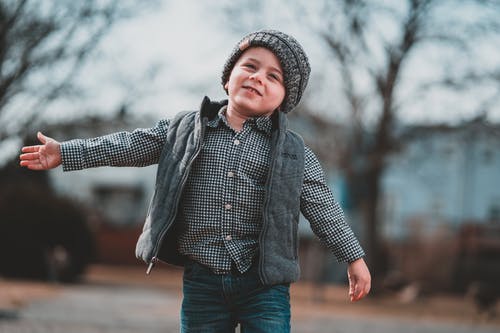 在路上行走的微笑男孩的选择性焦点照片 · 免费素材图片