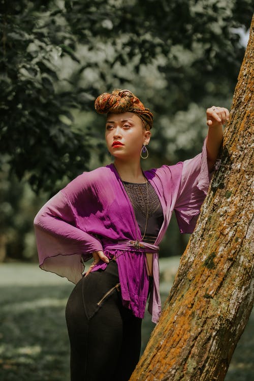 女人穿着紫色的衣服站在树前 · 免费素材图片