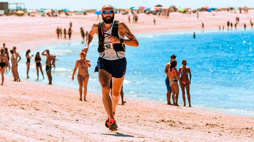 在海滩上奔跑的人的照片 · 免费素材图片