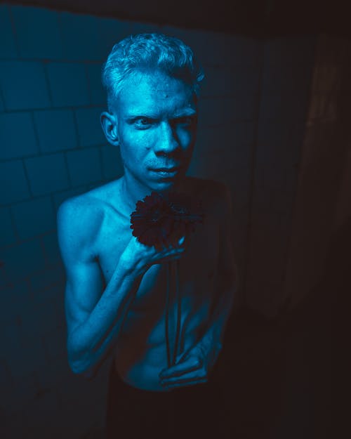 裸照的男人站在里面昏暗的蓝色点燃的房间 · 免费素材图片