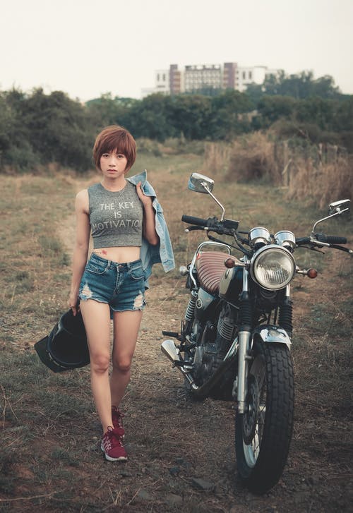 站在摩托车旁边的女人的照片 · 免费素材图片