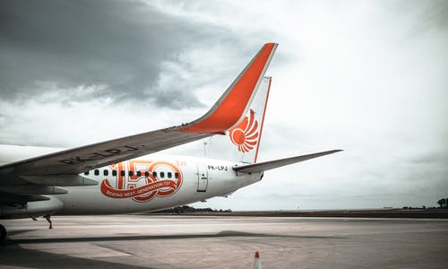停放的白色和橙色飞机 · 免费素材图片