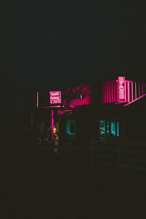 夜间建筑物的黑色和紫色霓虹灯招牌 · 免费素材图片