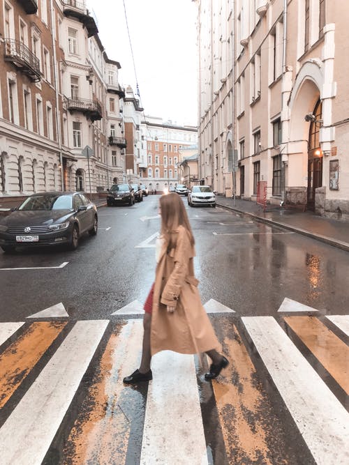 穿棕色大衣过马路的女人的照片 · 免费素材图片