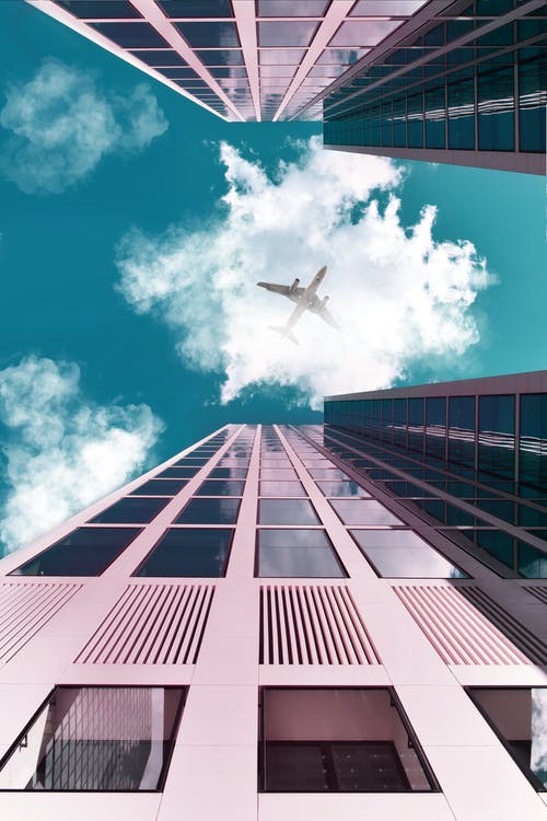 一架飞机飞越建筑物 · 免费素材图片