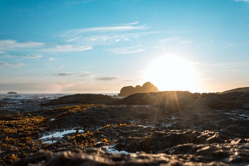 太阳照在大海的岩石海岸 · 免费素材图片