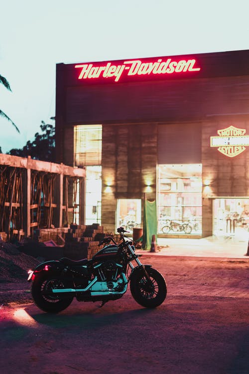 停在哈雷戴维森大楼附近的黑色和灰色摩托车 · 免费素材图片