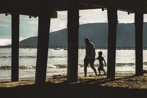 男人和孩子在岸上行走 · 免费素材图片