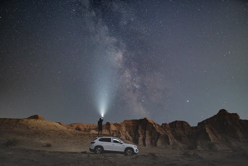 夜间站在车辆附近的人 · 免费素材图片