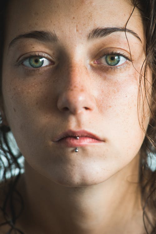 一个年轻的女人，与嘴唇穿孔的特写 · 免费素材图片