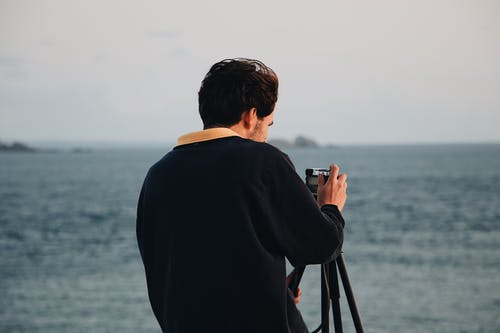 男子用他的相机的照片 · 免费素材图片