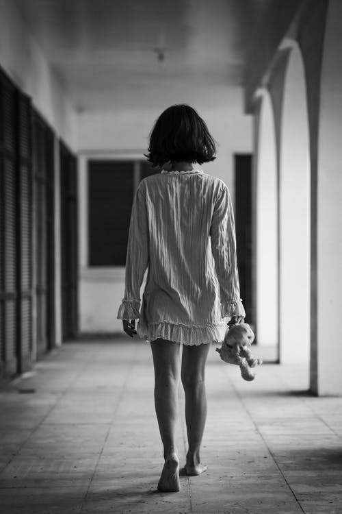 女人站在走廊上的单色照片 · 免费素材图片