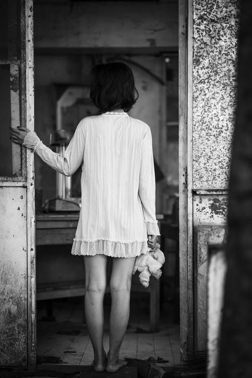 女人站在门口的单色照片 · 免费素材图片