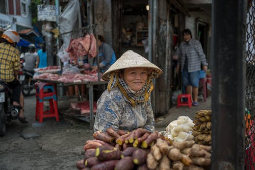 坐在她的商品旁边的女人 · 免费素材图片