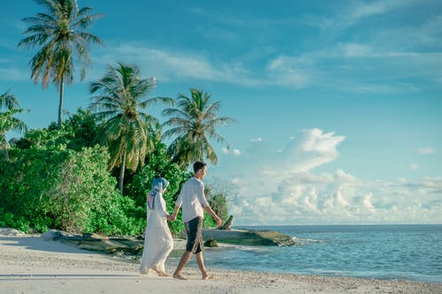 情侣牵手走在沙滩上的照片 · 免费素材图片