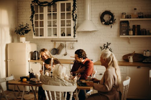 家人坐在厨房里的桌子上 · 免费素材图片